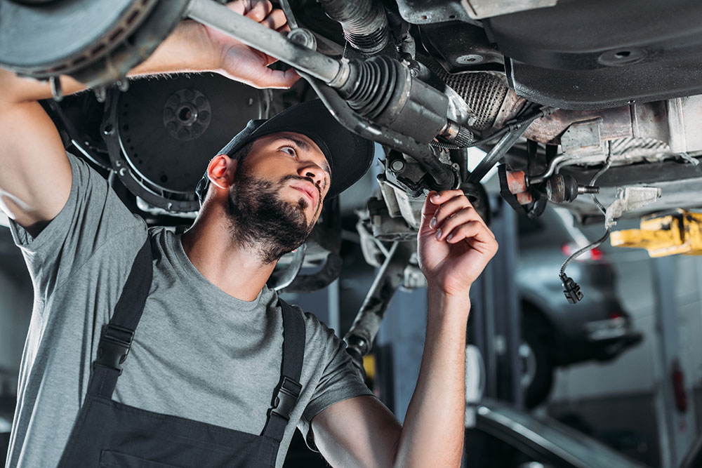 mechanic-in-overalls-repairing-car-in-auto-repair--4L7RS9J